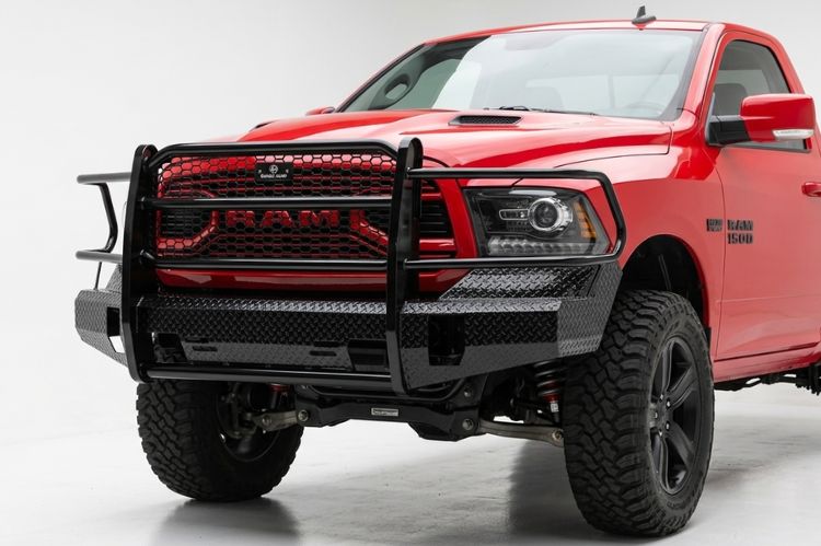 Close-up view of a Ranch Hand Summit Series front bumper with integrated brush guard and diamond-plate steel finish on a Dodge Ram 1500.
