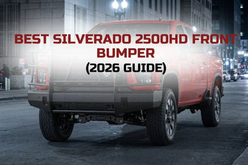 Chevy Silverado 2500HD with heavy-duty front bumper and grille guard driving in urban setting at night