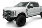 White truck's front end showcasing ADD Bomber Black bumper F810014110103, compatible with Ford Superduty models 2023-2025