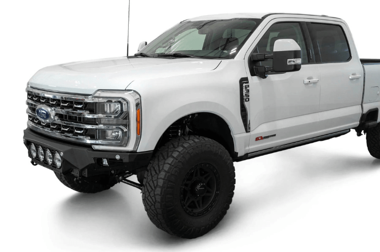 White truck's front end showcasing ADD Bomber Black bumper F810014110103, compatible with Ford Superduty models 2023-2025