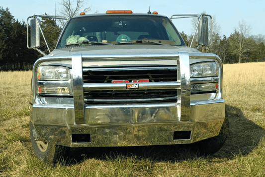 Front view of a Ali Arc Sentinel front bumper GMC Sierra 2500 3500 HD 2003-2006 chrome grille guard in a grassy field
