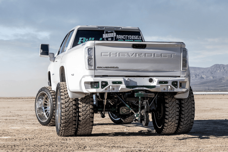 Aftermarket back bumper MFC20BYB for Chevy Silverado 2500/3500 with parking sensor cutouts and bare metal finish