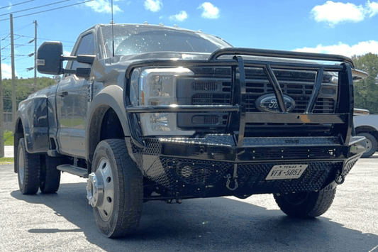 Bodyguard T2 Extreme front bumper replacement for 2023–2026 Ford F450/F550 Super Duty in texture black with parking sensor cutouts, camera harness, winch mount skid plate, and mesh grille.