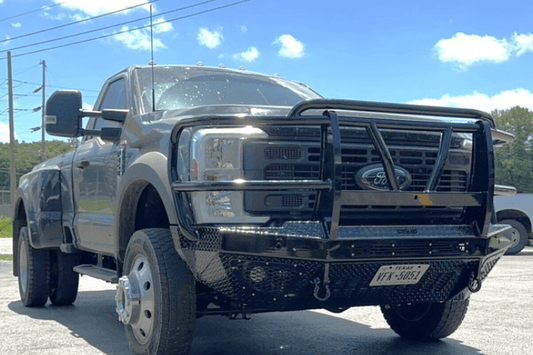 Bodyguard T2 Extreme front bumper with grille guard for Ford Super Duty F450/F550, texture black with parking sensor cutouts, camera harness, and winch mount skid plate.