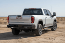 Upgraded 2023 GMC Sierra 2500HD featuring tough Fab Fours bumpers and sleek AMP Research steps