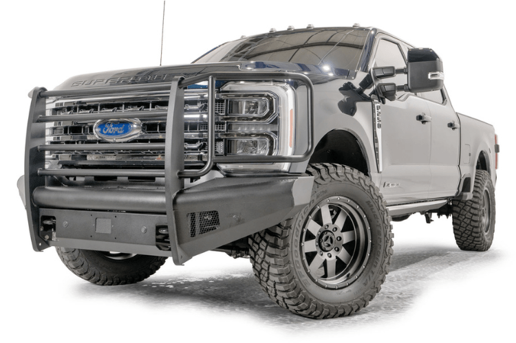 Fab Fours FS23-Q5960-1 Black Steel Elite Full Guard Front Bumper installed on a 2023 Ford F-250 Super Duty, featuring a matte black powder-coated finish, full grille guard, sensor compatibility, and mounts for 3x3 LED cube lights.