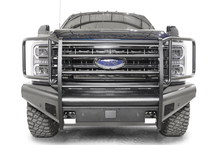 Fab Fours FS23-Q5960-1 Black Steel Elite Full Guard Front Bumper installed on a 2023 Ford F-250 Super Duty, featuring a matte black powder-coated finish, full grille guard, sensor compatibility, and mounts for 3x3 LED cube lights.