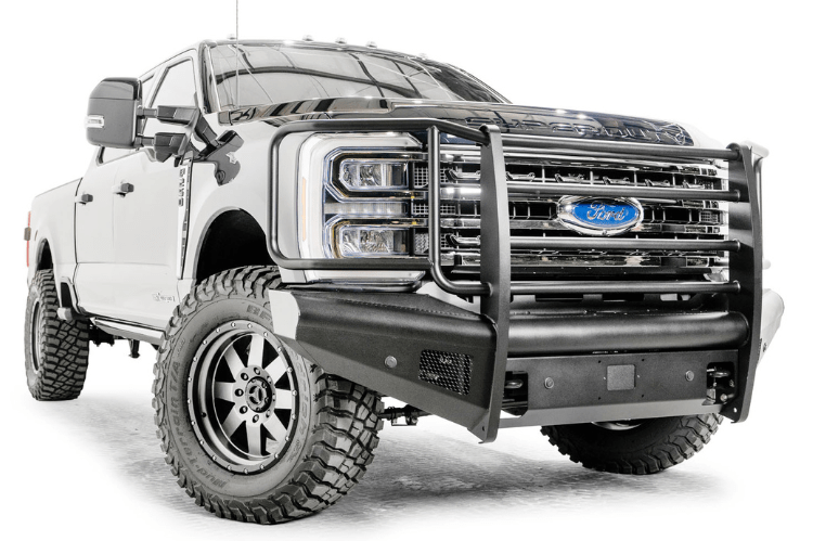 Fab Fours FS23-Q5960-1 Black Steel Elite Full Guard Front Bumper installed on a 2023 Ford F-250 Super Duty, featuring a matte black powder-coated finish, full grille guard, sensor compatibility, and mounts for 3x3 LED cube lights.