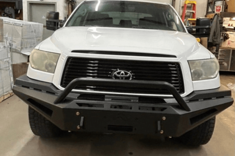 Fab Fours Red Steel TT07-RS1862-1 Front Bumper with Winch Ready Pre-Runner Guard for 2007-2013 Toyota Tundra in a warehouse setting