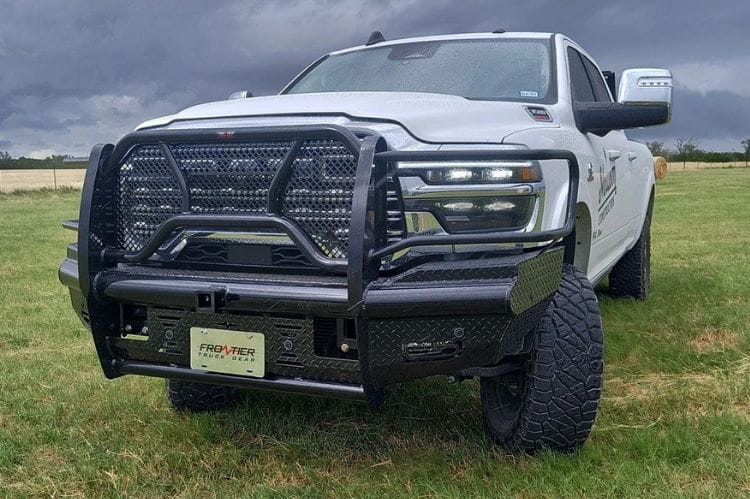 White truck with a Frontier Commercial Front Bumper Replacement for 2025 Dodge Ram 2500 and 3500, heavy-duty diamond plate steel on a grassy field