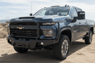 2025 Chevrolet Silverado 2500HD equipped with the Overland Adventure Kit, featuring Fab Fours front and rear bumpers, WARN VR EVO 12-S winch, TruXedo Elevate FS rack, and ARB rooftop tent for off-road adventure and cargo versatility