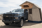 2025 Chevrolet Silverado 2500HD equipped with the Overland Adventure Kit, featuring Fab Fours front and rear bumpers, WARN VR EVO 12-S winch, TruXedo Elevate FS rack, and ARB rooftop tent for off-road adventure and cargo versatility