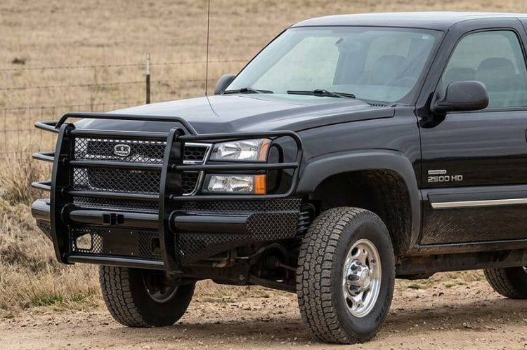 Side view of Ranch Hand FBC031BLR front bumper for 2003–2007 Chevy Silverado 2500HD and 3500 Classic trucks on a dirt road