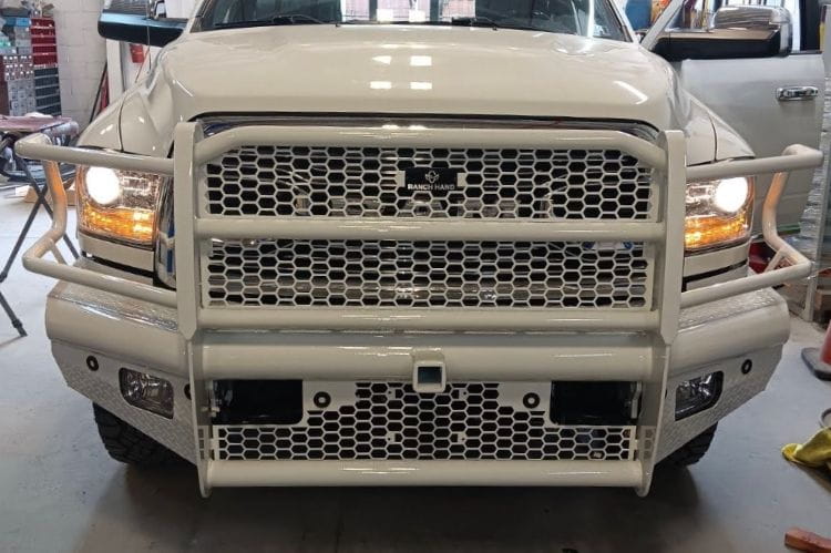Ranch Hand FBD101BLRS Legend front bumper on white 2010-2018 Dodge Ram 2500 heavy duty truck in a garage setting