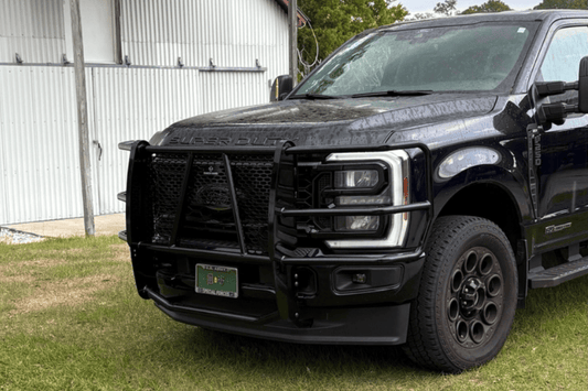 Ranch Hand Legend Series Grille Guard for 2023-2026 Ford F250 and F350 Super Duty, heavy-duty black pipe steel on grass in front of a building