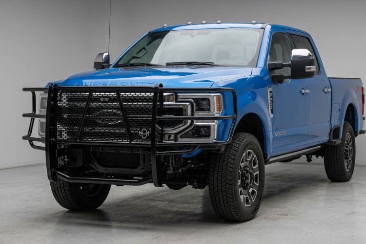 Blue pickup truck with Ranch Hand Legend Series Grille Guard for 2023-2026 Ford F250 and F350 Super Duty, heavy-duty black pipe steel in a showroom setting