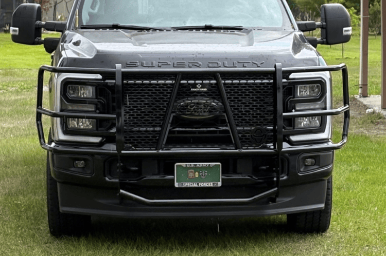 Front view of a Ranch Hand Legend Series Grille Guard for 2023-2026 Ford F250 and F350 Super Duty, heavy-duty black pipe steel on grass.
