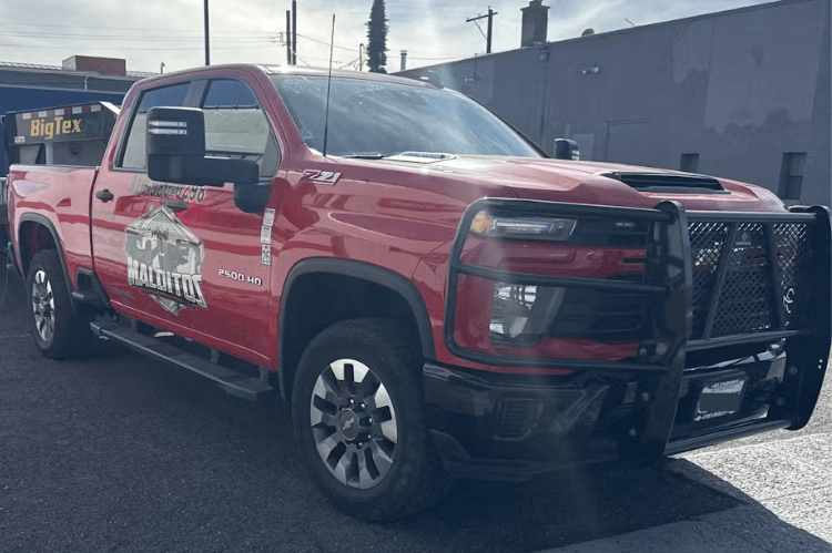 Red pickup truck with Ranch Hand Legend Series Grille Guard GGC241BL1 installed on a 2024-2026 Chevy Silverado 2500HD 3500HD diesel truck on a paved surface.