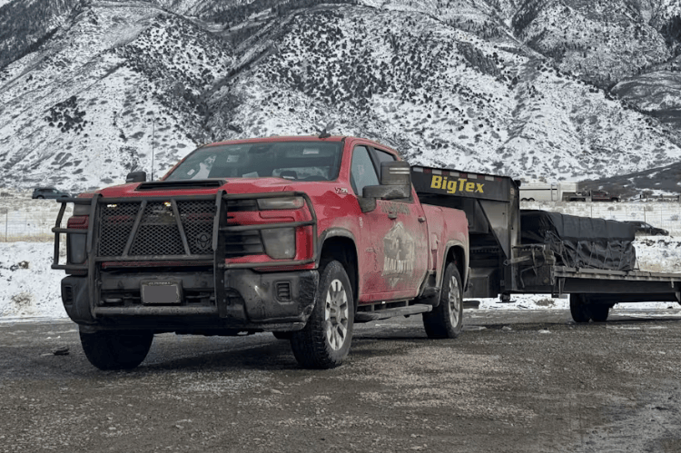 Red pickup truck towing a trailer Ranch Hand Legend Series Grille Guard GGC241BL1 installed on a 2024-2026 Chevy Silverado 2500HD 3500HD diesel truck.