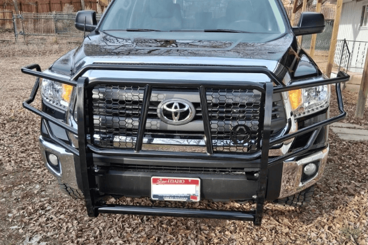 Black Ranch Hand Legend Series Heavy Duty Grille Guard GGT14HBL1 for 2014-2021 Toyota Tundra Trucks a gravel surface.