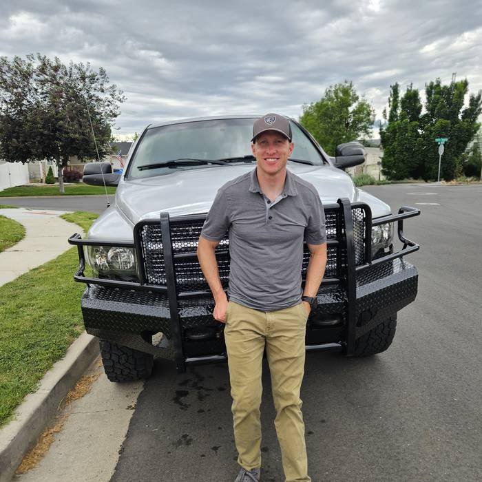 A customer standing in front of his Ram with a new Ranch Hand grille guard